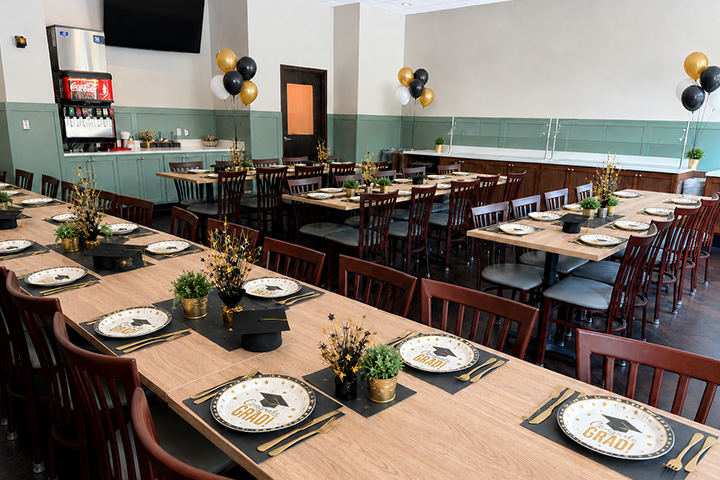 Large party room with multiple tables formal place settings.